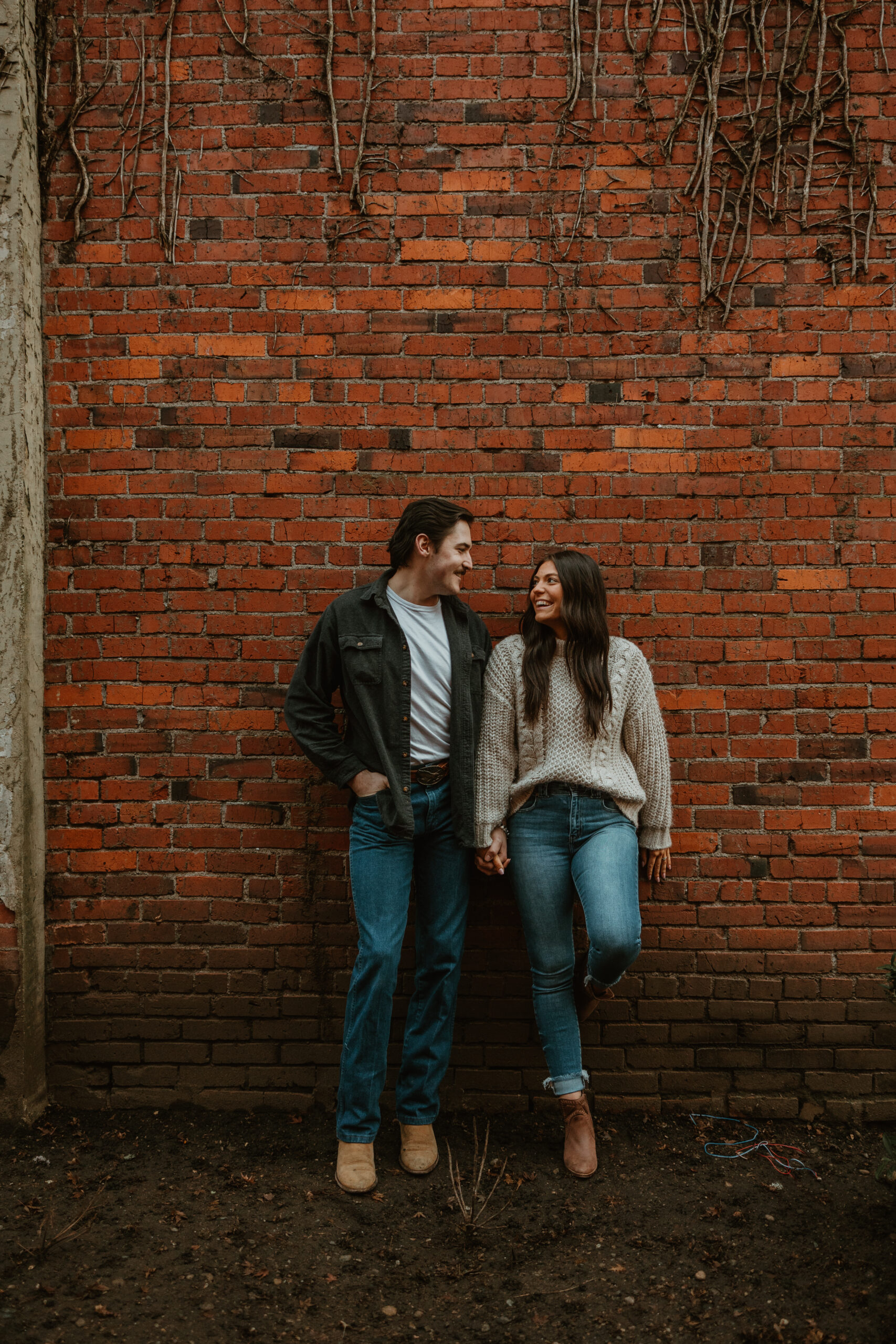 couple leaning against a brick wall in Centralia washington