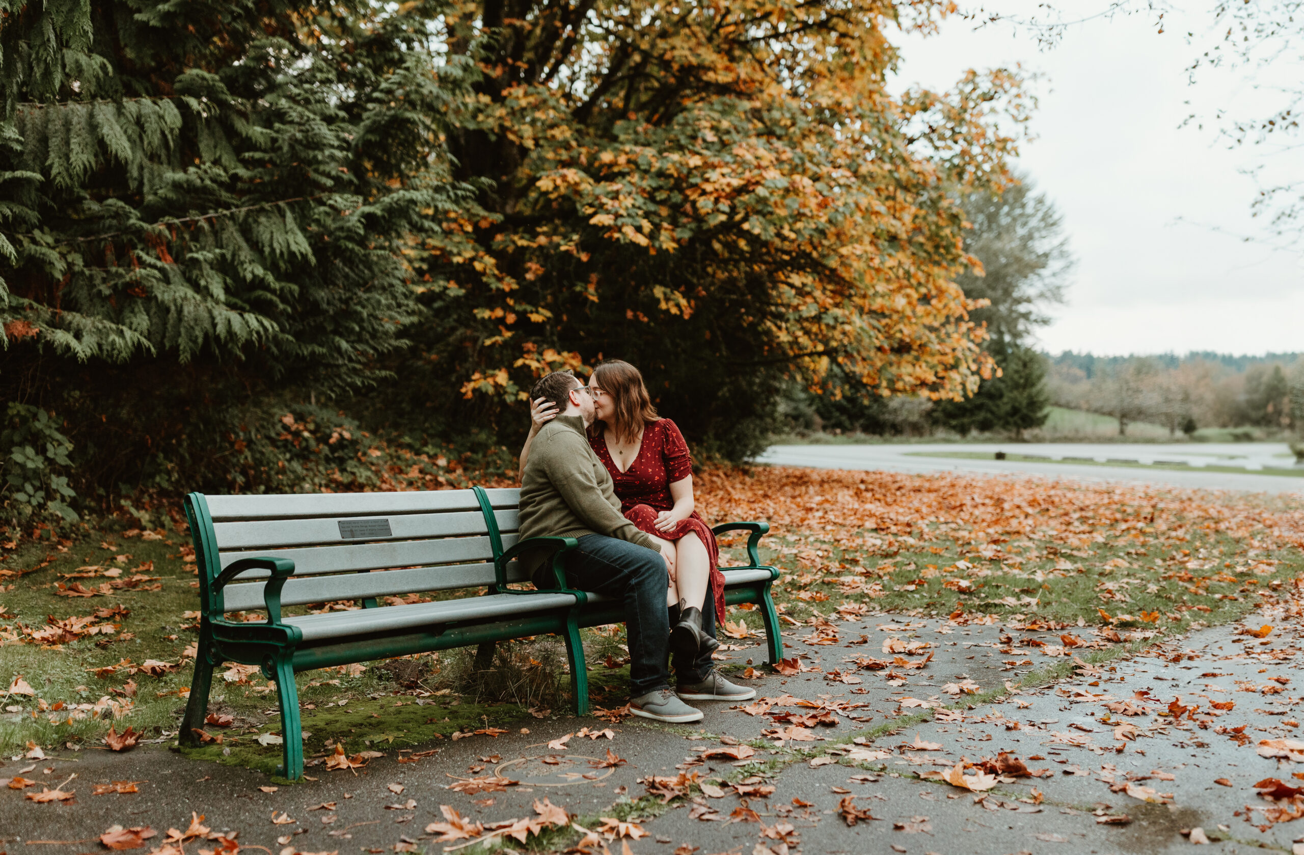 man and woman kissing on a bench