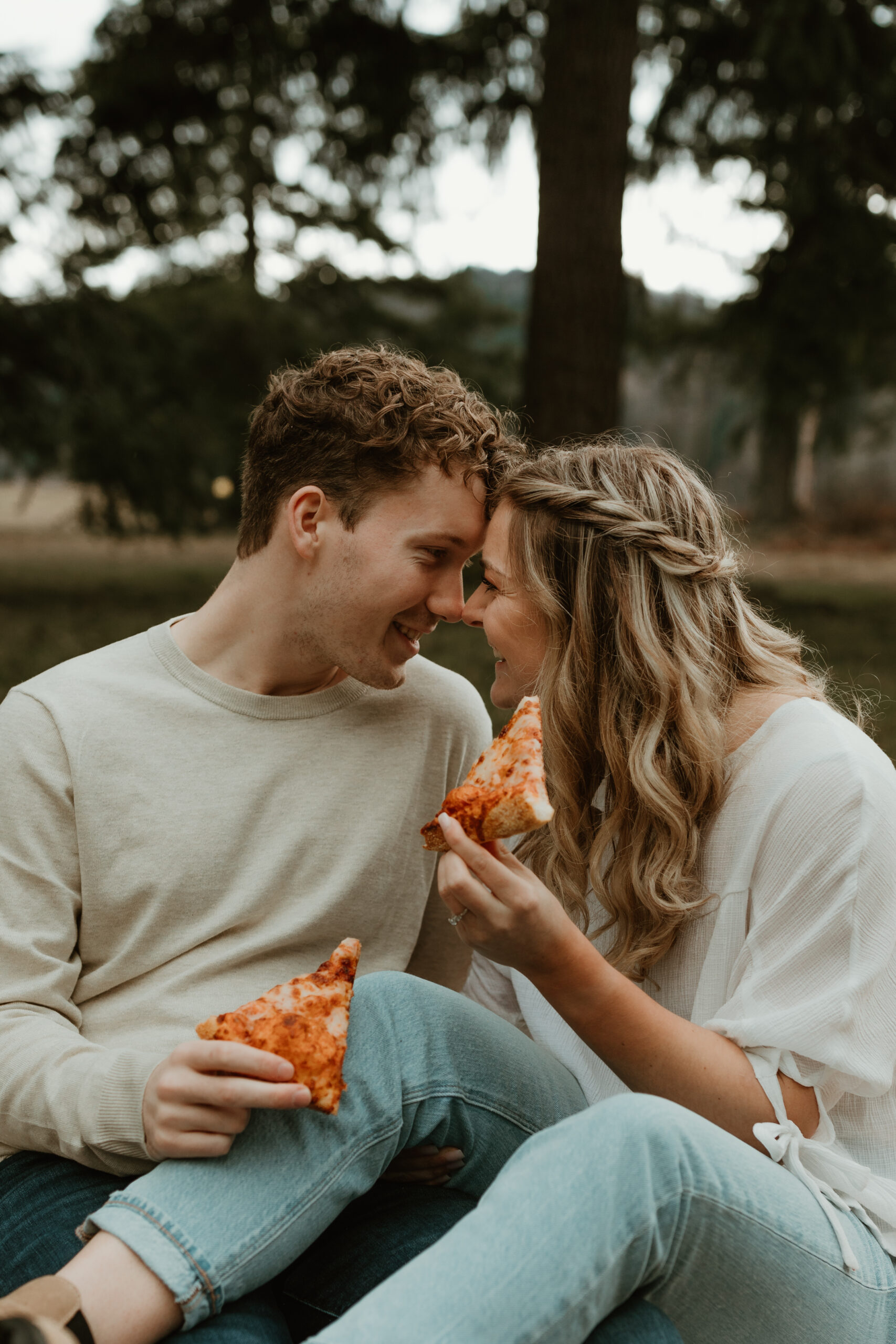 couple sitting and eating pizza together for their engagement session