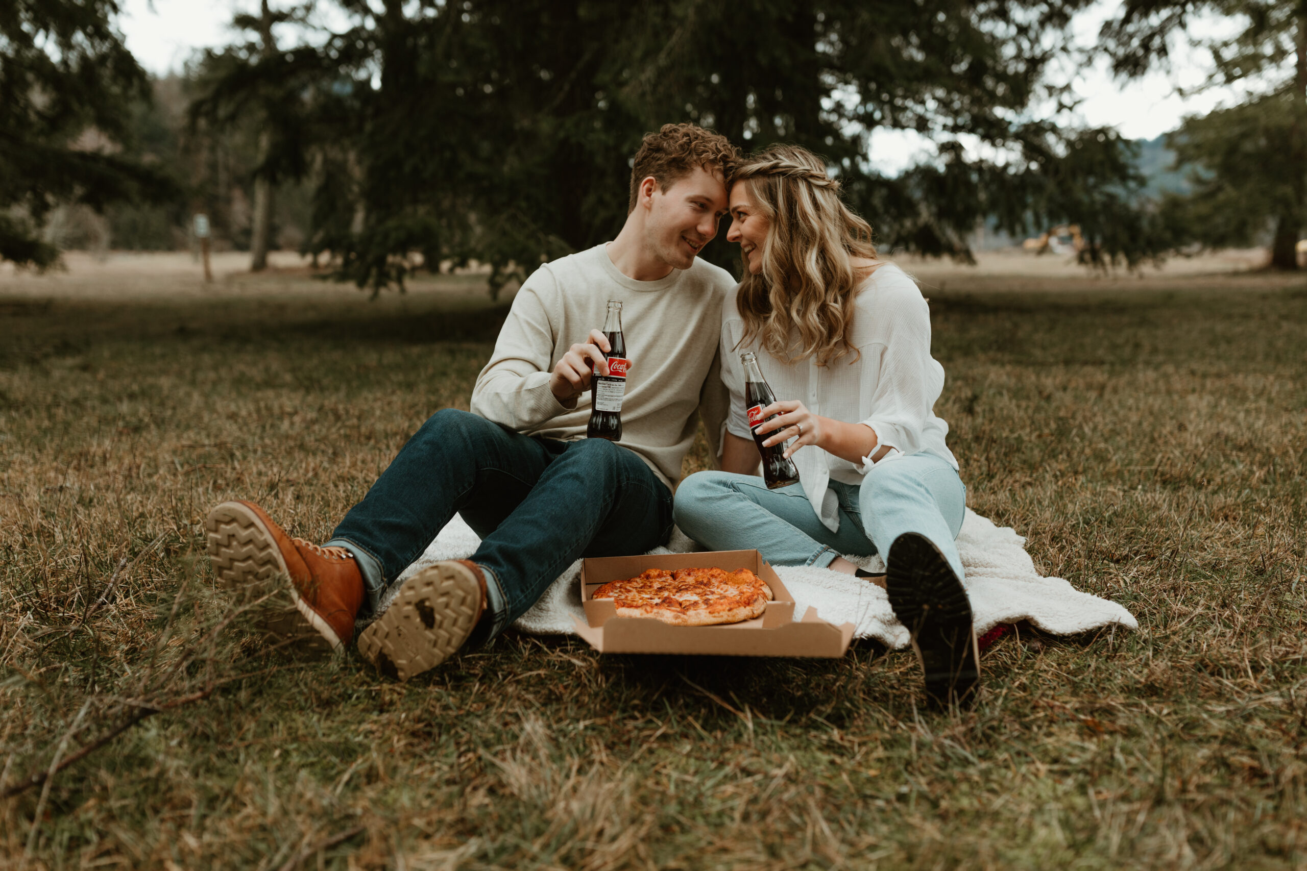 couple eating pizza in a field