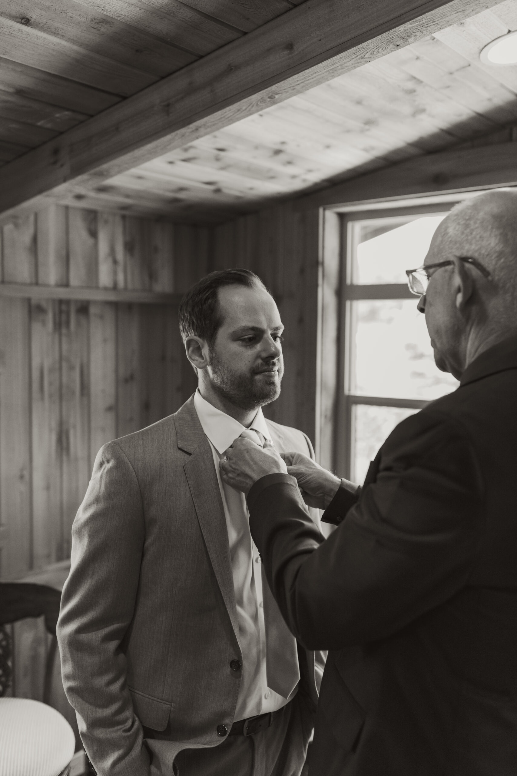 father of the groom fixes the grooms tie