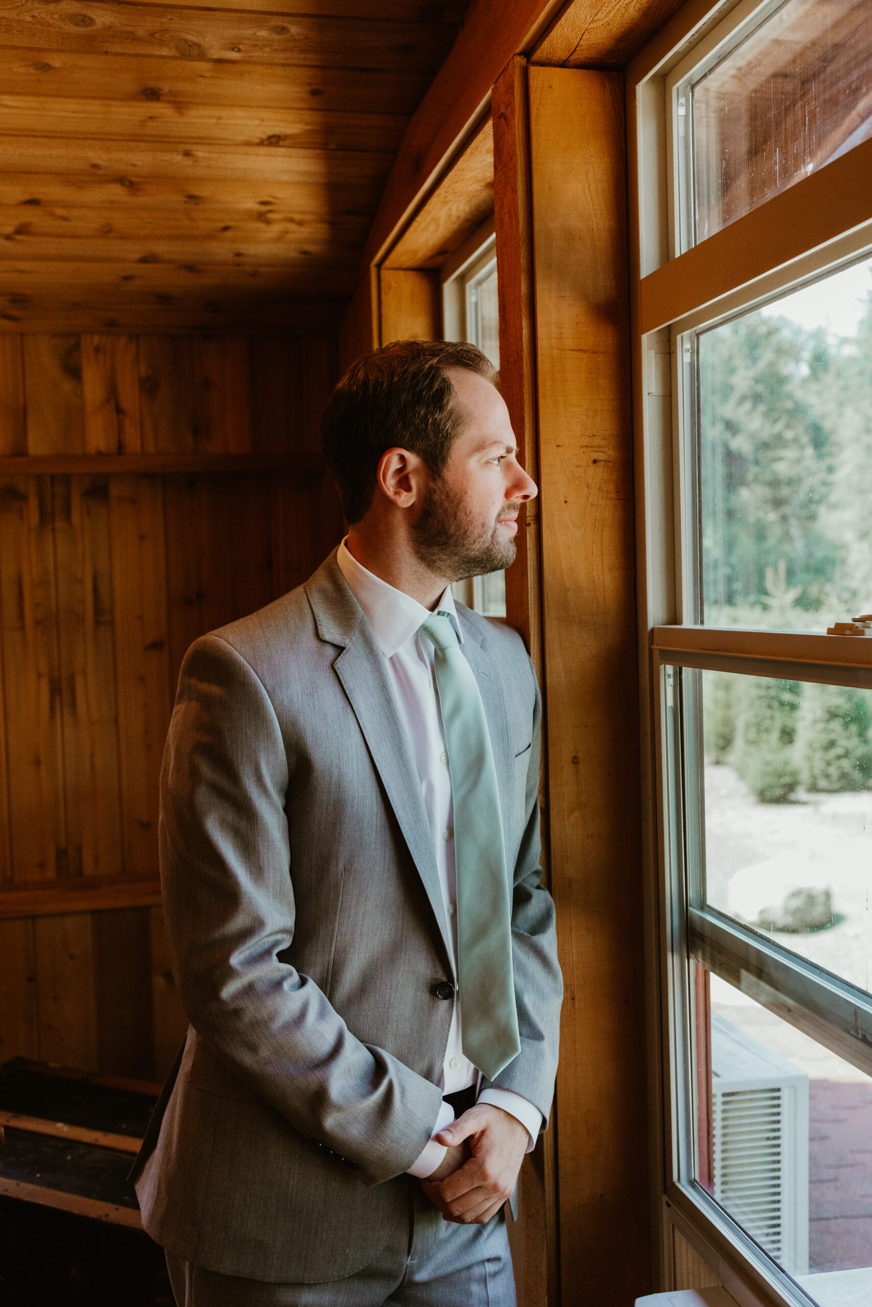 groom looking out the window in Issaquah, Washington