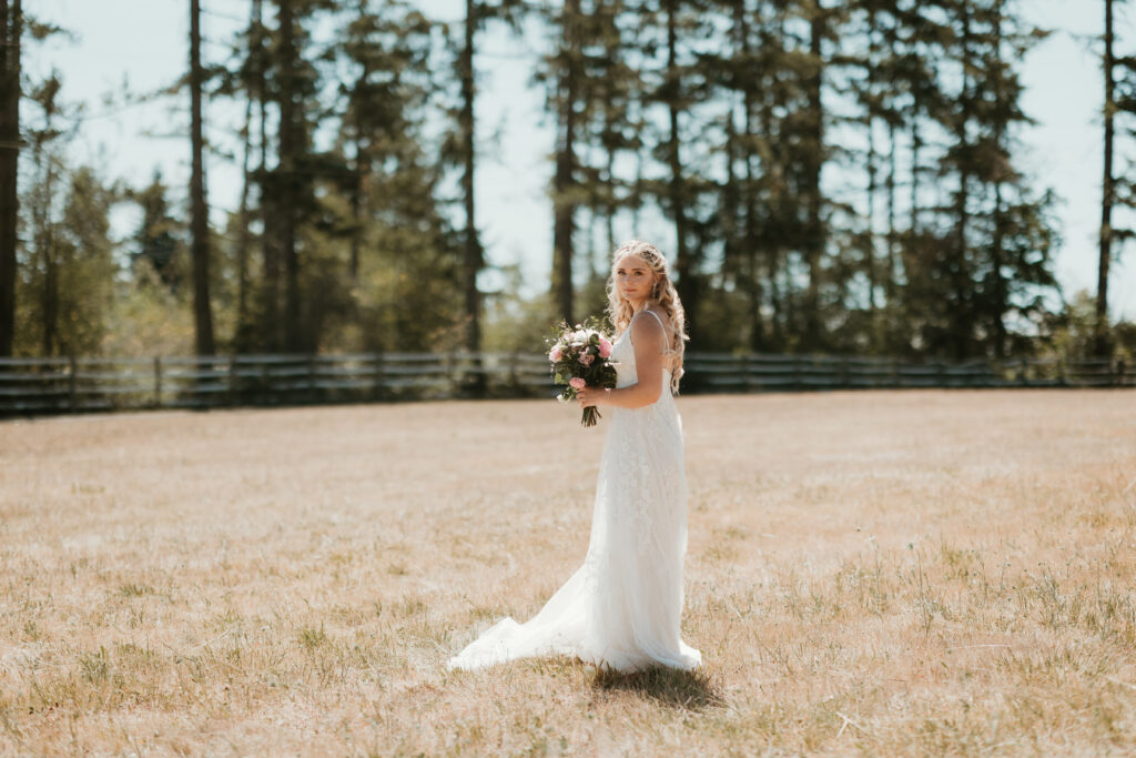 bride standing alone in a field