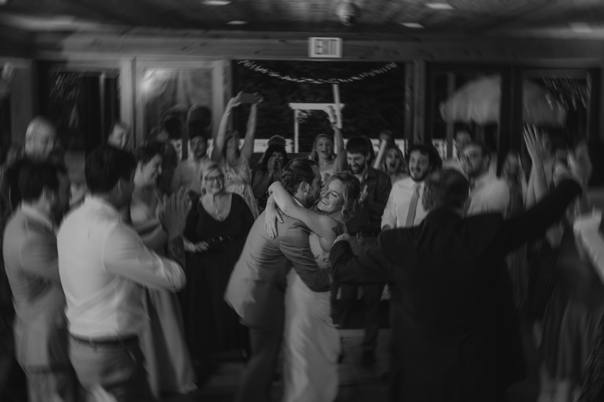 bride and groom dancing with their friends and family