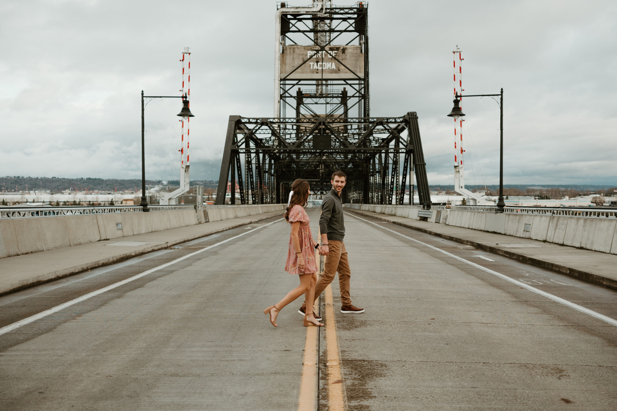 man and woman walking across a bridge in tacoma