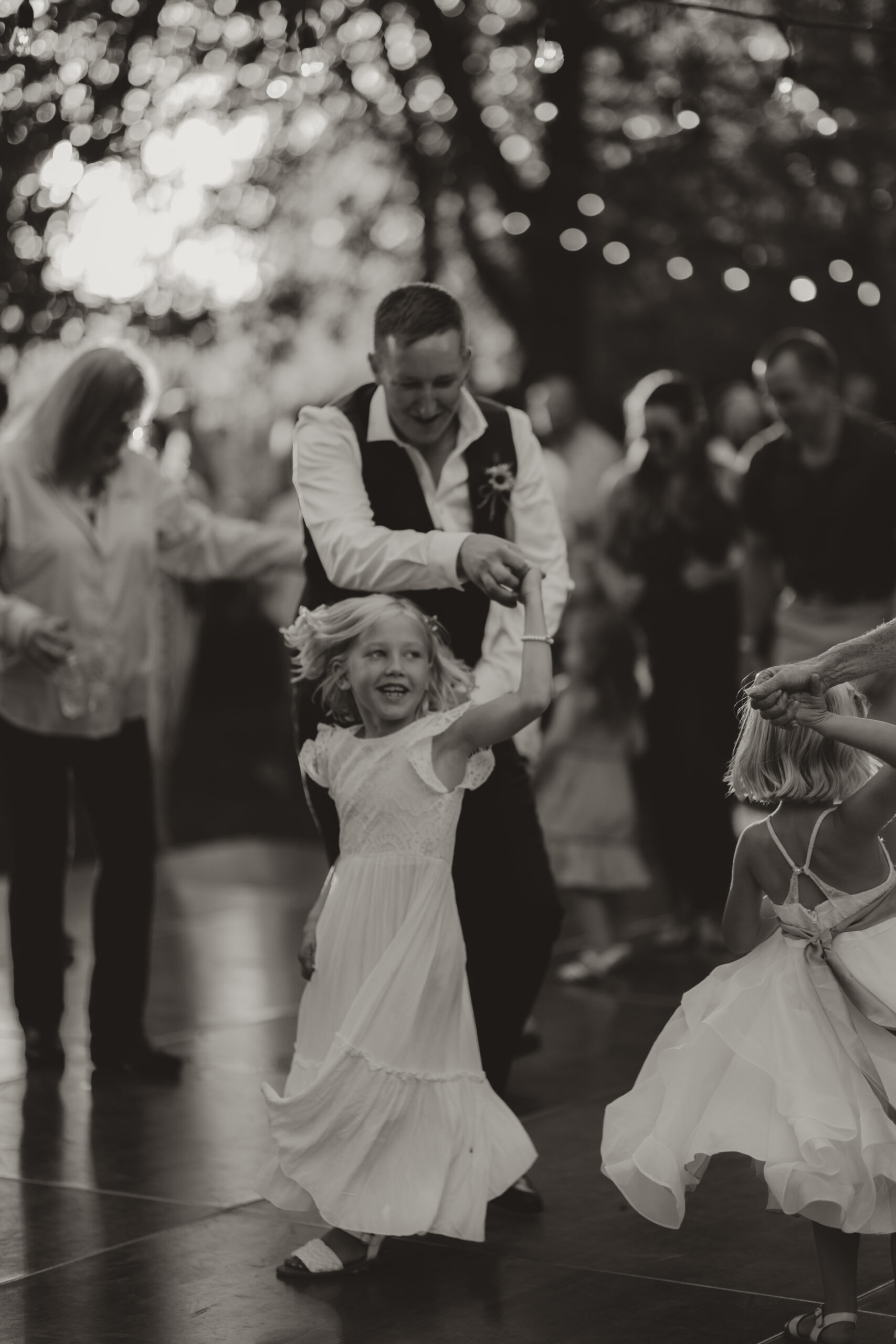groom dancing with the flower girl at his wedding