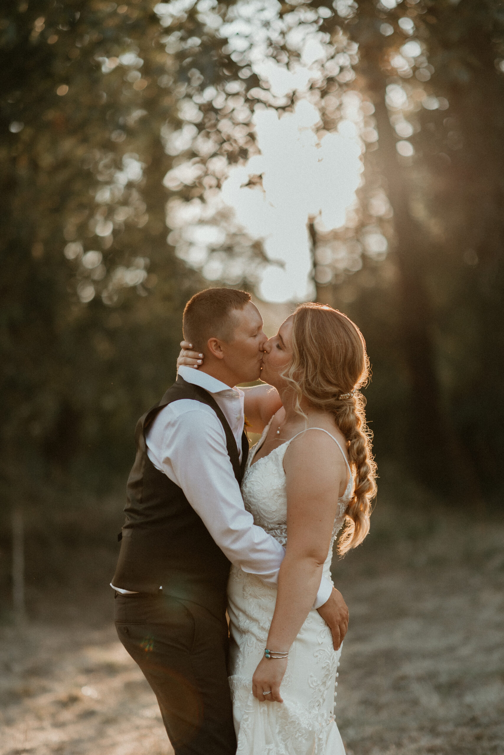 bride and groom kissing in a field at golden hour
