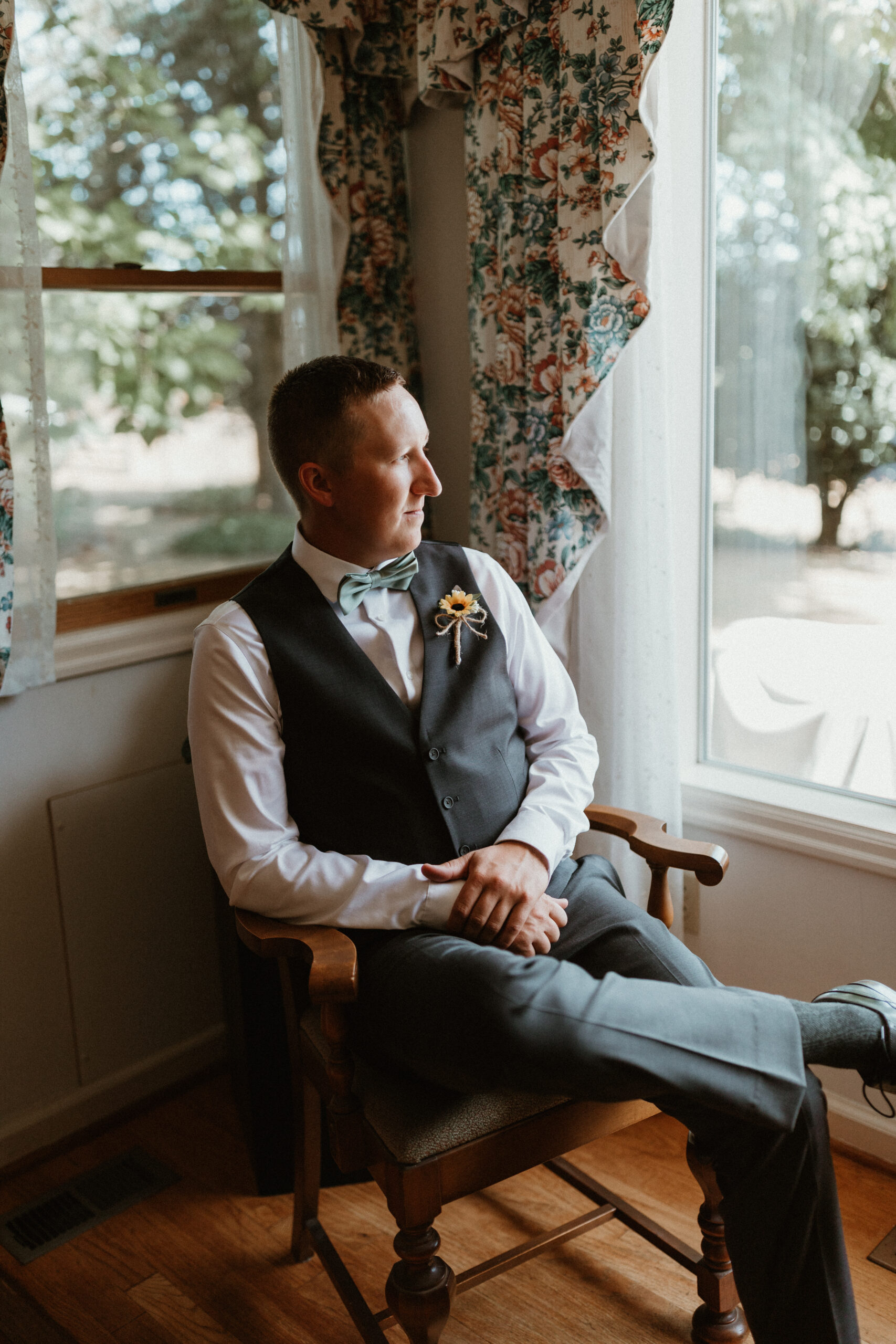 groom looking out the window of a house