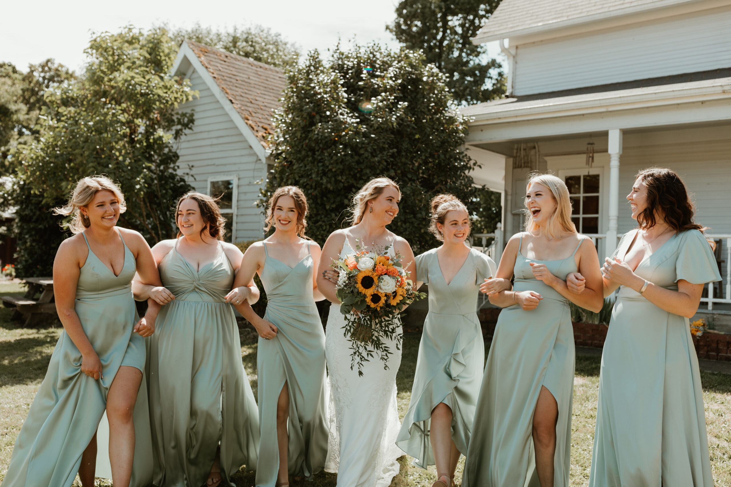 bridesmaids laughing and walking together in a field