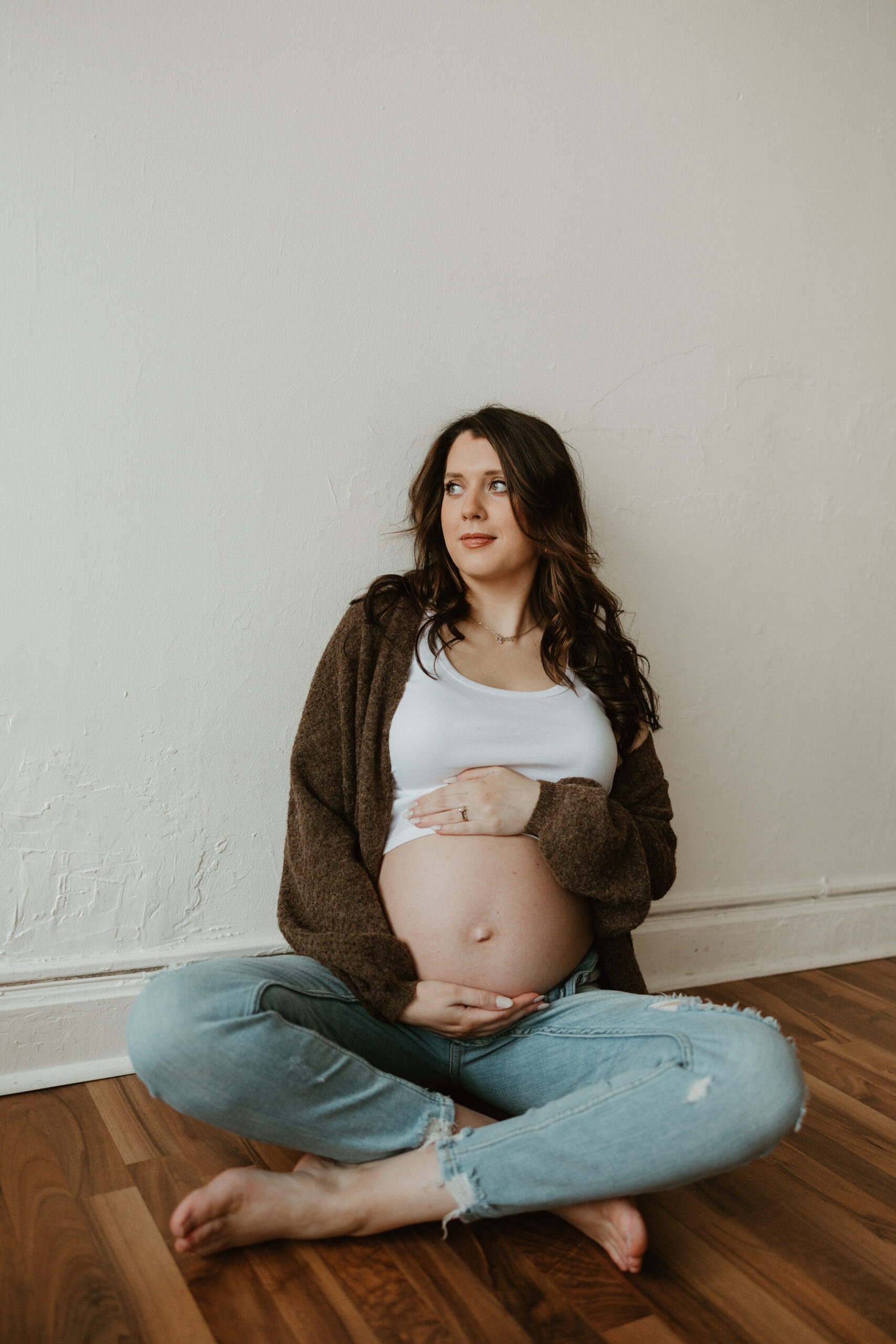 a mother holding her baby belly and sitting down